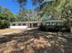 Charming single-story home with lush landscaping and mature trees providing ample shade at 22 Poinsettia Dr, Deland, FL 32724