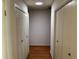 Hallway has hardwood floors, a skylight, and closet space on both sides for ample storage at 22 Poinsettia Dr, Deland, FL 32724