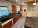 Cozy kitchen featuring warm wood cabinets, black countertops, double basin sink, and blue tiled floors at 22 Poinsettia Dr, Deland, FL 32724