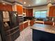 Charming kitchen featuring rich wood cabinets, modern appliances, and a stylish island with a contrasting blue base at 22 Poinsettia Dr, Deland, FL 32724