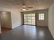Bright living room with ceiling fan, door to outside, and large window bringing in natural light at 22 Poinsettia Dr, Deland, FL 32724