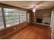 Inviting living room boasts wood floors, a brick fireplace, and large windows showcasing scenic outdoor views at 22 Poinsettia Dr, Deland, FL 32724