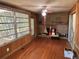 Cozy living room featuring a brick fireplace and a wood paneled sunroom at 22 Poinsettia Dr, Deland, FL 32724