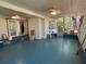 Spacious screened porch with ceiling fans, and blue floors with natural lighting at 22 Poinsettia Dr, Deland, FL 32724