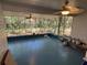Open screened porch with wooded views, ceiling fans and blue painted floor at 22 Poinsettia Dr, Deland, FL 32724