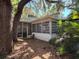 View of the screened in porch, surrounded by mature trees and lush greenery at 22 Poinsettia Dr, Deland, FL 32724