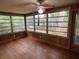 Inviting sun room featuring wood floors, wood paneled walls and multiple large windows looking out onto the yard at 22 Poinsettia Dr, Deland, FL 32724