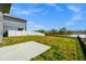 Backyard view featuring a concrete patio, pond, and white vinyl privacy fence at 2222 Derwent Dr, Davenport, FL 33896