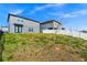 Backyard view with a lawn and a two-story home featuring black-framed doors at 2222 Derwent Dr, Davenport, FL 33896