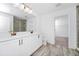 Bright bathroom with a double sink vanity, wood-style tile flooring, and a glass-enclosed shower at 2222 Derwent Dr, Davenport, FL 33896