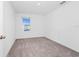 Simple bedroom featuring neutral carpet, white walls, and natural light from the window at 2222 Derwent Dr, Davenport, FL 33896