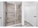 Spacious walk-in shower featuring sleek tile, glass enclosure, and modern fixtures at 2222 Derwent Dr, Davenport, FL 33896