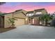 Inviting tan two-story home with attached garage, mature landscaping, and brick accents at sunset at 229 Springside Rd, Longwood, FL 32779