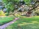 Expansive lawn with a brick path leading through mature trees, enhanced by Spanish moss at 229 Springside Rd, Longwood, FL 32779