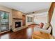 Cozy living room with a brick fireplace, hardwood floors, and large windows at 229 Springside Rd, Longwood, FL 32779