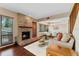 Inviting living room featuring a brick fireplace, hardwood floors, and a view of the dining area at 229 Springside Rd, Longwood, FL 32779