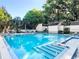 Outdoor pool area with lounge chairs and pool house, surrounded by lush trees at 229 Springside Rd, Longwood, FL 32779