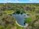 Aerial view of the property's natural spring bordered by palms, mature trees and concrete walkway at 229 Springside Rd, Longwood, FL 32779