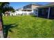 Spacious backyard with lush green grass, palm tree, and white vinyl fence at 2305 Biscotto Cir, Davenport, FL 33897