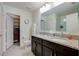 This bathroom is equipped with double granite sinks, a toilet, and a walk-in closet at 2305 Biscotto Cir, Davenport, FL 33897