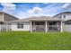 Back exterior view showing screened patio and well-maintained lawn at 2305 Biscotto Cir, Davenport, FL 33897