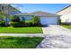 Well-maintained front yard with green grass and tasteful landscaping leading to a two-car garage at 2305 Biscotto Cir, Davenport, FL 33897