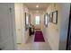 Bright hallway with neutral tile flooring, decorative wall art, and access to various rooms at 2305 Biscotto Cir, Davenport, FL 33897