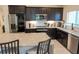 Well-equipped kitchen boasts dark wood cabinets, stainless steel appliances, and a granite-topped island with seating at 2305 Biscotto Cir, Davenport, FL 33897