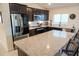 Modern kitchen with dark cabinetry, stainless steel appliances, and a large granite-topped island at 2305 Biscotto Cir, Davenport, FL 33897