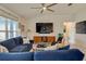 Bright living room showcasing plush blue sofas, modern furnishings, and a large window for natural light at 2305 Biscotto Cir, Davenport, FL 33897