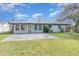 Backyard featuring a gray patio, light gray siding, white trim, and a lush green lawn at 250 Domino Dr, Orlando, FL 32805