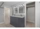 Bathroom featuring dual sink vanity, modern mirrors, and linen closet at 250 Domino Dr, Orlando, FL 32805