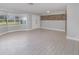 Spacious living room featuring wood-look tile flooring, large window and an accent wall at 250 Domino Dr, Orlando, FL 32805