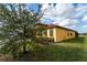 A shot of the house and yard, obscured by a tree, in a well maintained community at 2610 Rosemont Cir, Davenport, FL 33837