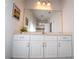 Bright bathroom featuring a vanity with white cabinets, a large mirror, and modern lighting fixtures at 2610 Rosemont Cir, Davenport, FL 33837