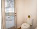 Bathroom with a toilet, and door to the backyard with privacy blinds at 2610 Rosemont Cir, Davenport, FL 33837