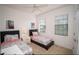 Bright bedroom with twin beds, white walls, and natural light streaming through the windows at 2610 Rosemont Cir, Davenport, FL 33837