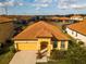 Charming home with a terracotta tile roof, a covered entryway, and a well-manicured yard at 2610 Rosemont Cir, Davenport, FL 33837