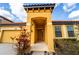 Inviting entrance to a yellow house with a red tile roof, enhancing curb appeal and highlighting architectural details at 2610 Rosemont Cir, Davenport, FL 33837