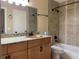 This bathroom features a granite countertop, wood vanity, framed mirror, and tiled shower and bath at 285 Wymore Rd # 204, Altamonte Springs, FL 32714