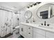 Bathroom with double sink vanity, black fixtures, decorative mirrors, and a walk-in shower at 304 Dover St, Orlando, FL 32811