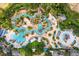 Aerial view of an elaborate resort pool area with multiple pools, slides, palm trees, and lounge chairs at 314 Muirfield Loop, Reunion, FL 34747