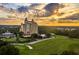 Stunning aerial view of a resort featuring lush landscaping, golf course, and sunset at 314 Muirfield Loop, Reunion, FL 34747