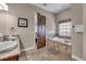 Luxurious bathroom featuring a soaking tub, natural stone accents, and wood door at 314 Muirfield Loop, Reunion, FL 34747