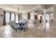 Elegant dining room with travertine floors, a chandelier, and an arched entrance to the open kitchen at 314 Muirfield Loop, Reunion, FL 34747