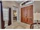 Bright foyer featuring large double doors, tile flooring, and a glimpse into the main bedroom at 314 Muirfield Loop, Reunion, FL 34747