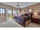 Comfortable main bedroom features a balcony, plush bedding, and elegant decor at 314 Muirfield Loop, Reunion, FL 34747