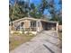 Charming single-story home featuring a screened porch and covered carport with a paved driveway at 31700 Orange St, Sorrento, FL 32776