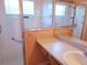 Bathroom showing a shower with glass doors and single sink with a mirror at 3567 Capland Ave, Clermont, FL 34711