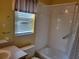 Bright bathroom featuring a shower-tub combo and large window at 3567 Capland Ave, Clermont, FL 34711